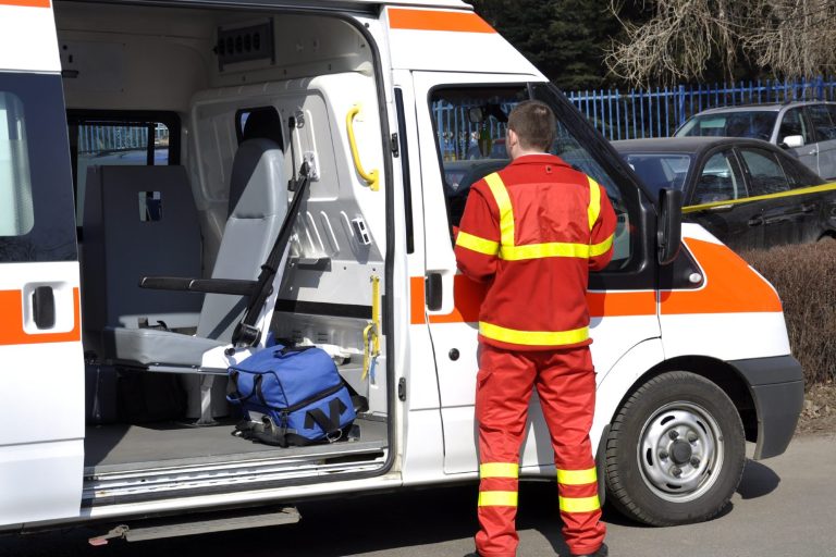 Rettungsdienstmitarbeiter steht an einer offenen Ambulanz mit Ausrüstung.